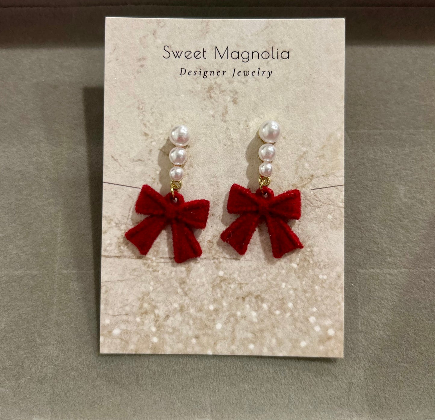 Earrings with pearls and a dangling red bow