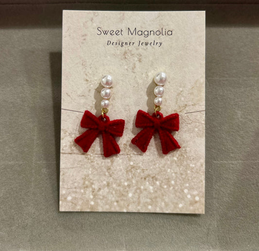 Earrings with pearls and a dangling red bow